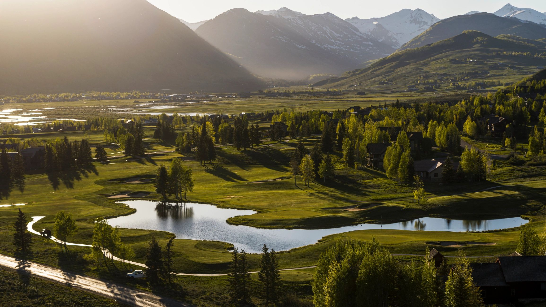 Mountain landscape with a manicured golf course at golden hour