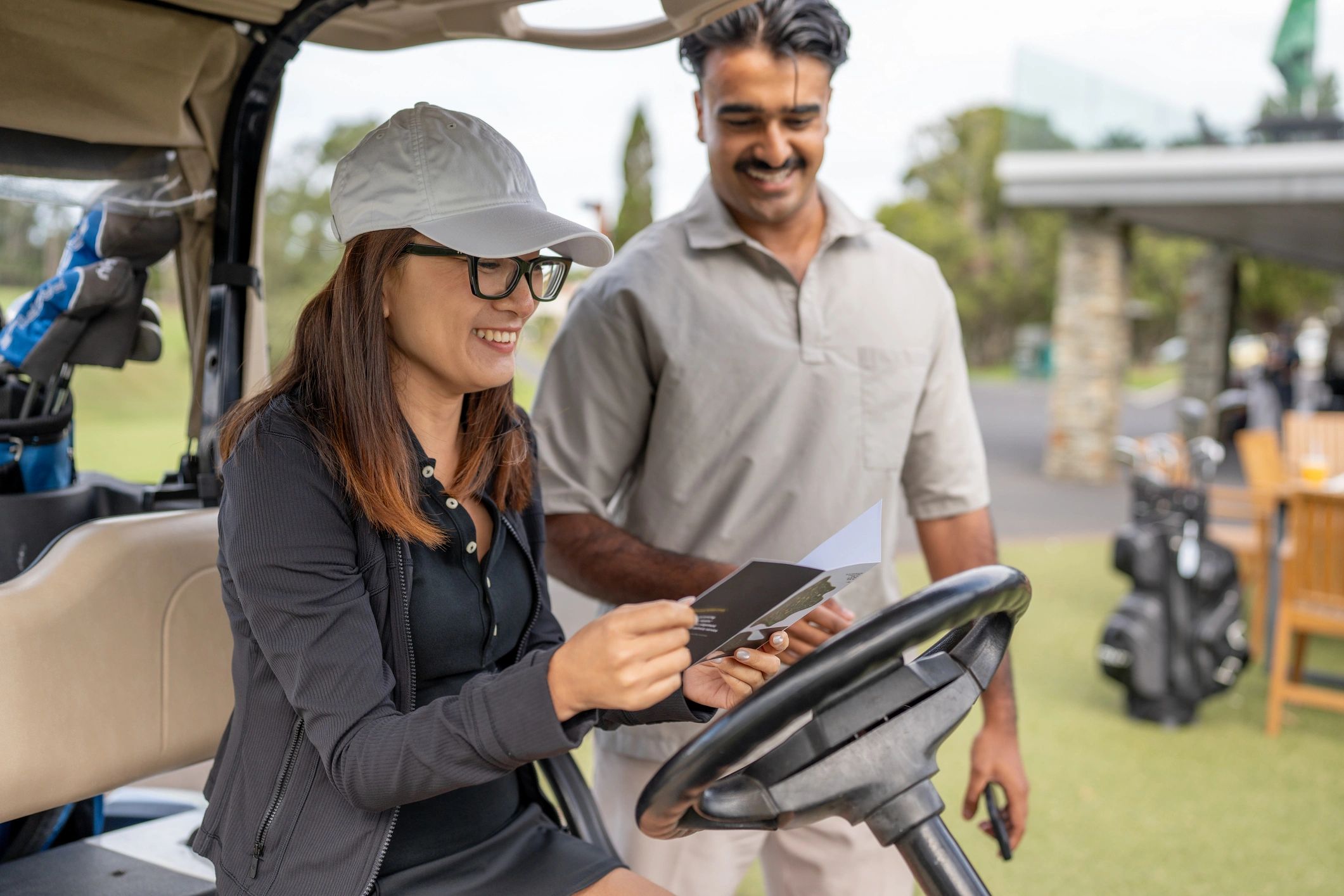 Two golfers reviewing a scorecard in a cart